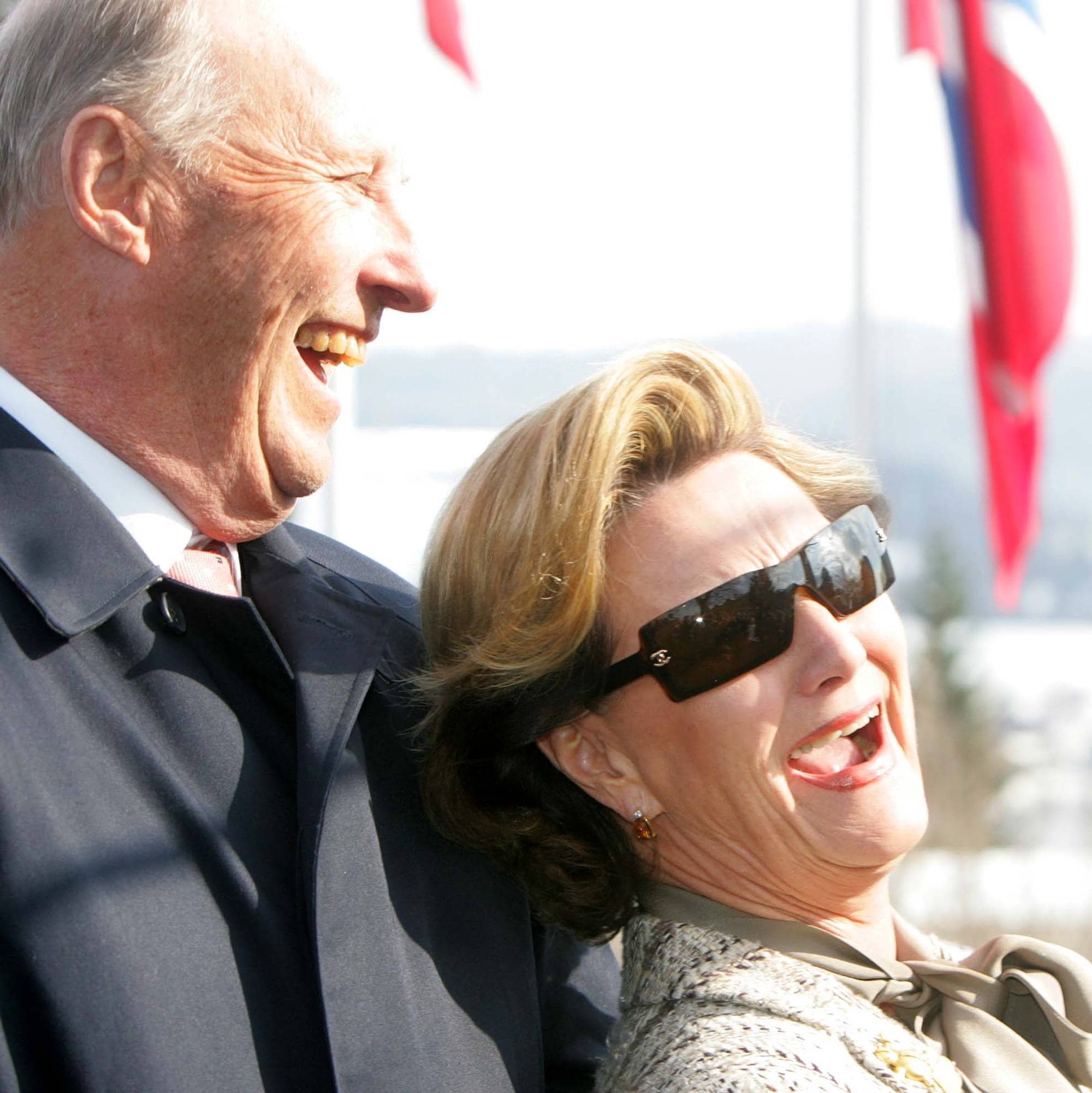 Kong Harald og dronning Sonja smiler og ler under et statsbesøk i Sveits.