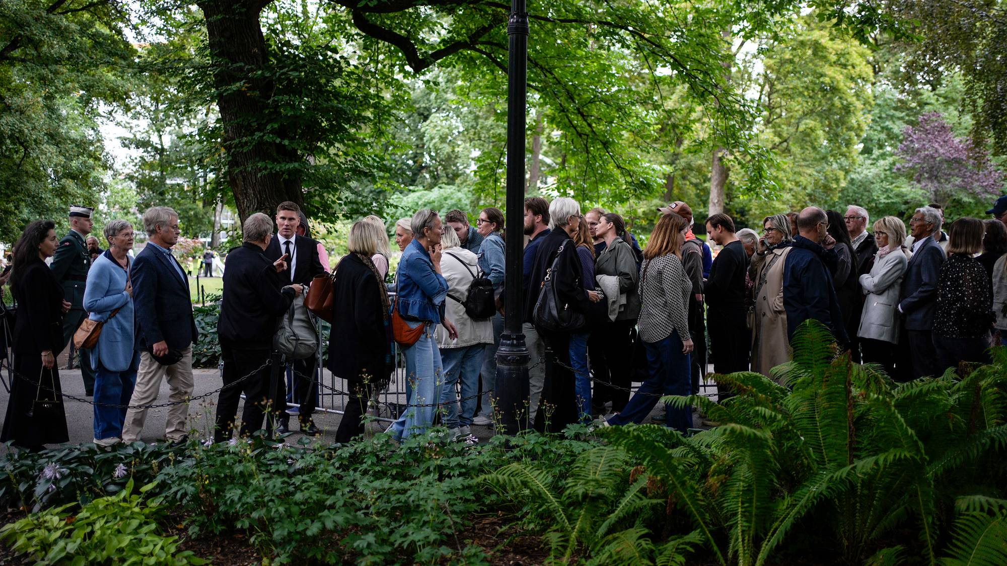 en gruppe mennesker som står i kø på vei inn i slottskapellet