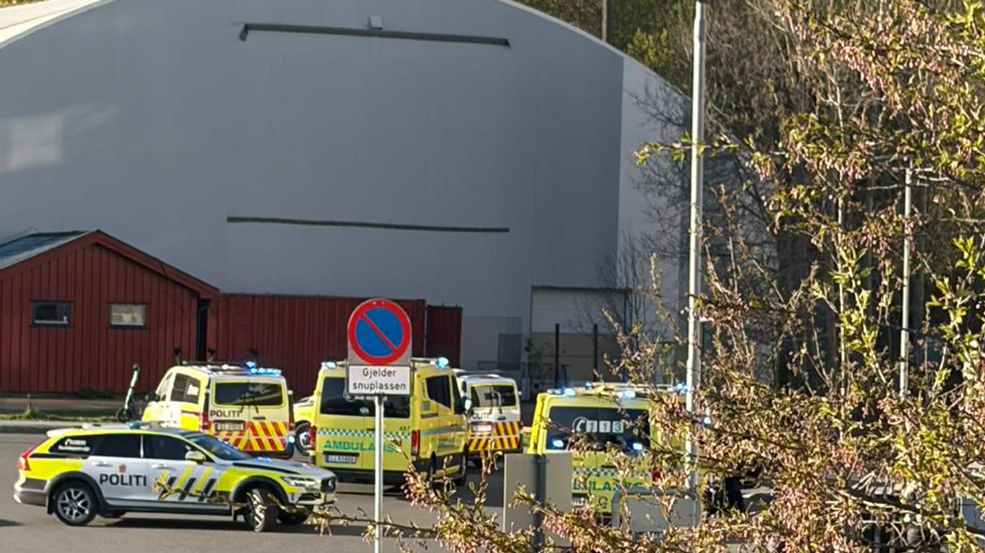 Bildet viser en rekke politibiler ved en idrettshall.
