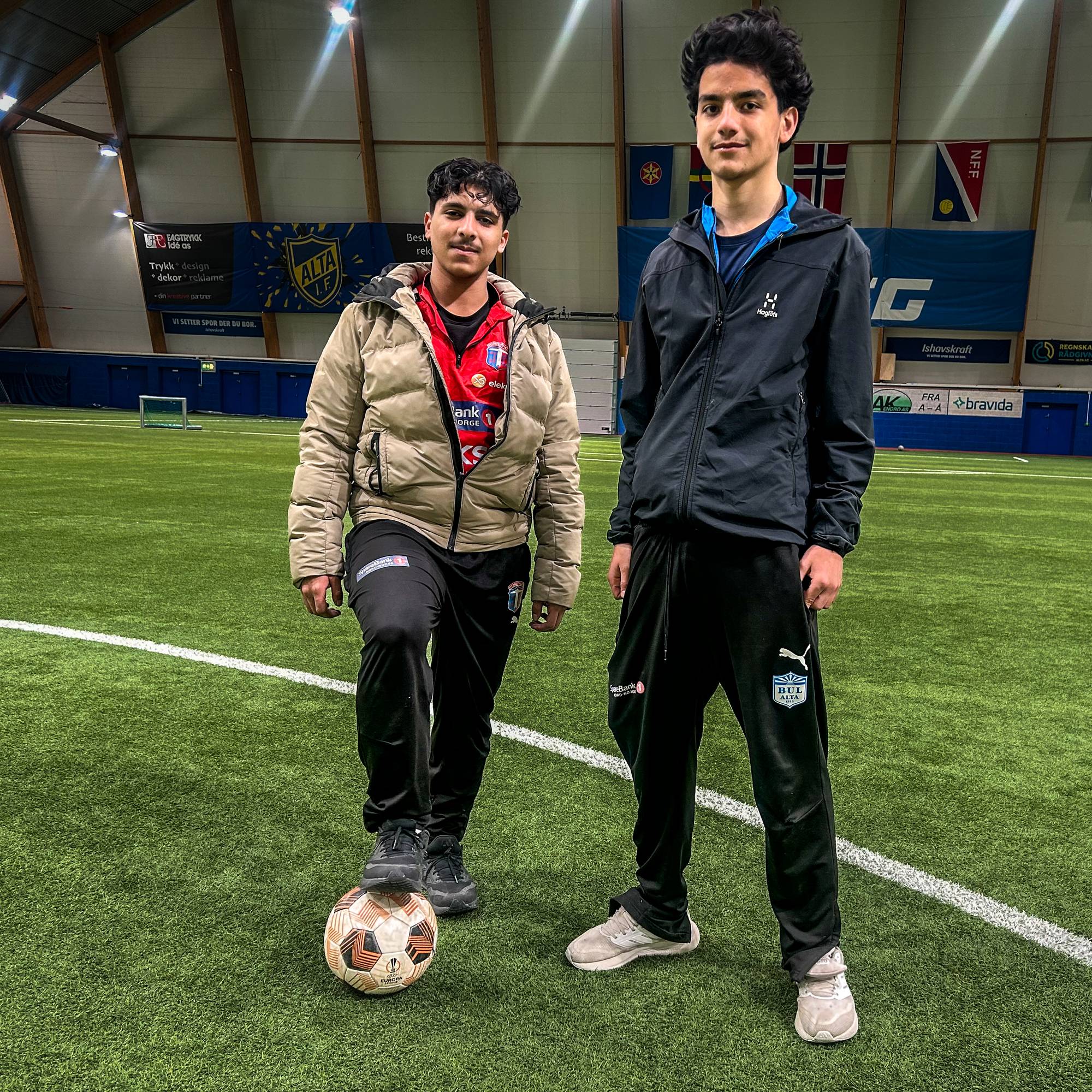 To gutter står i en fotballhall med en fotball