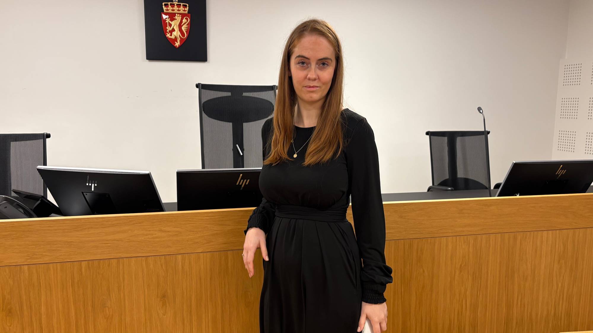 Kvinne i svart kjole som ser i kamera