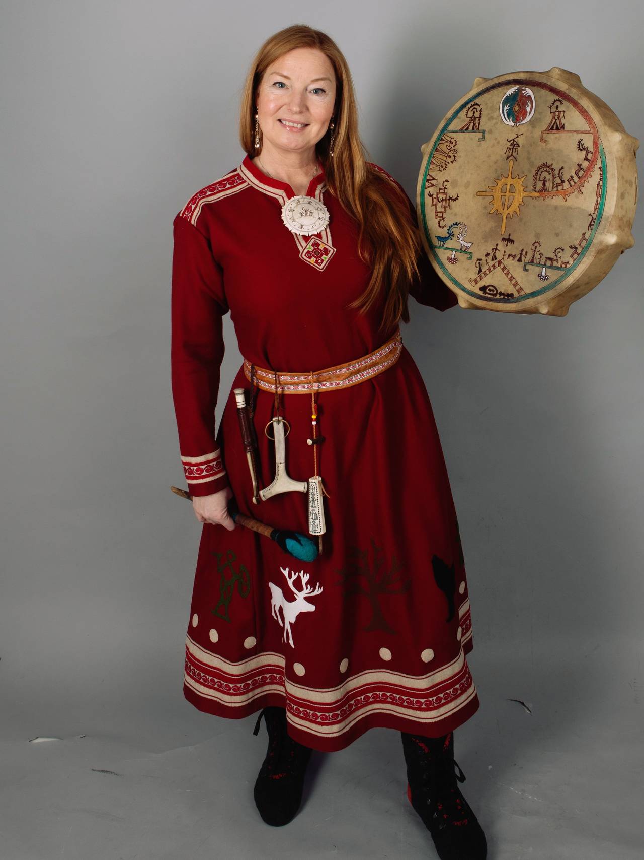 Totalbilde av Lone i seremonidrakt som hun bruker ved trommereiser ol.