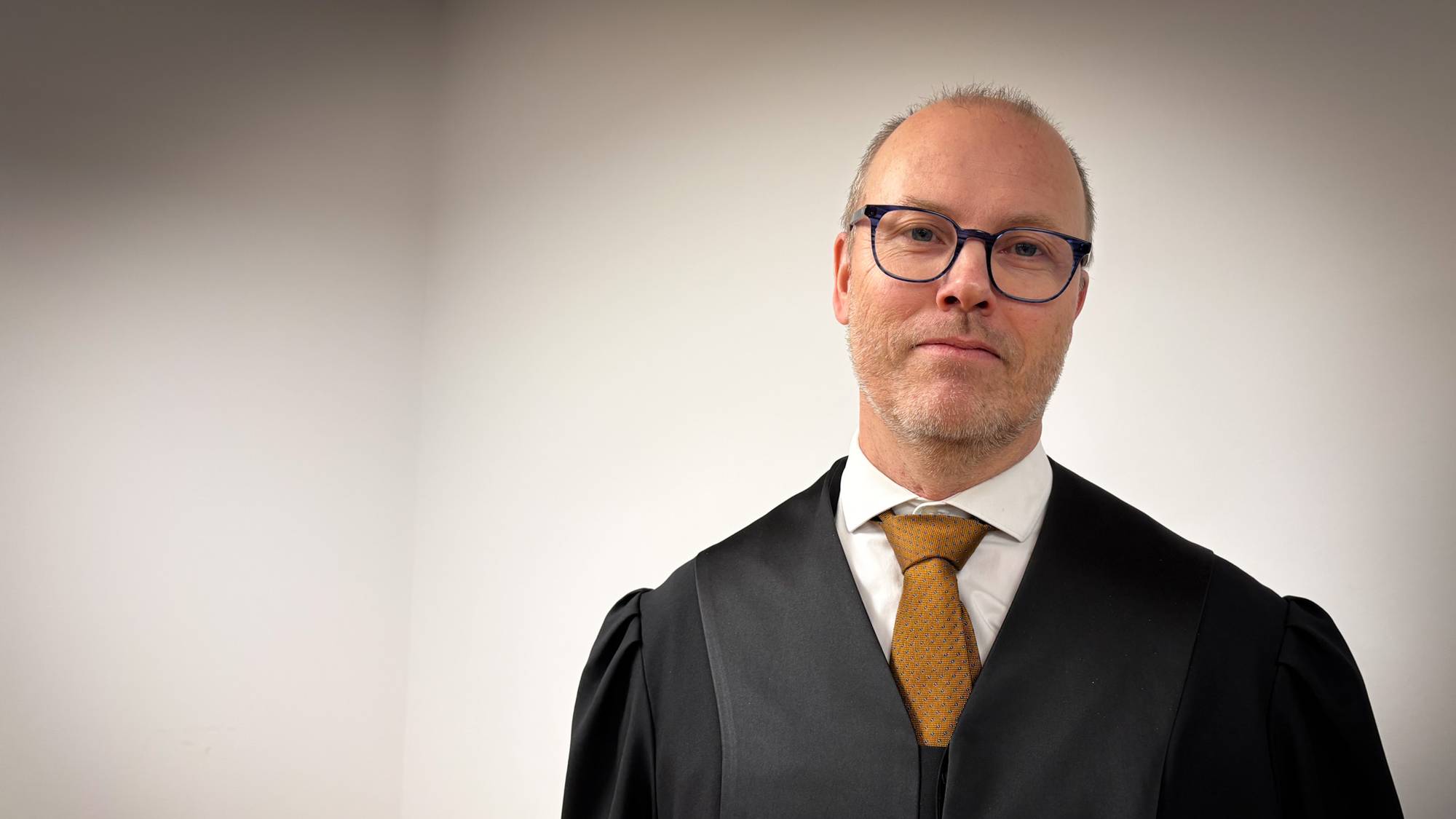 en mann iført dress og slips (Bildebeskrivelsen er laget av en KI-tjeneste)