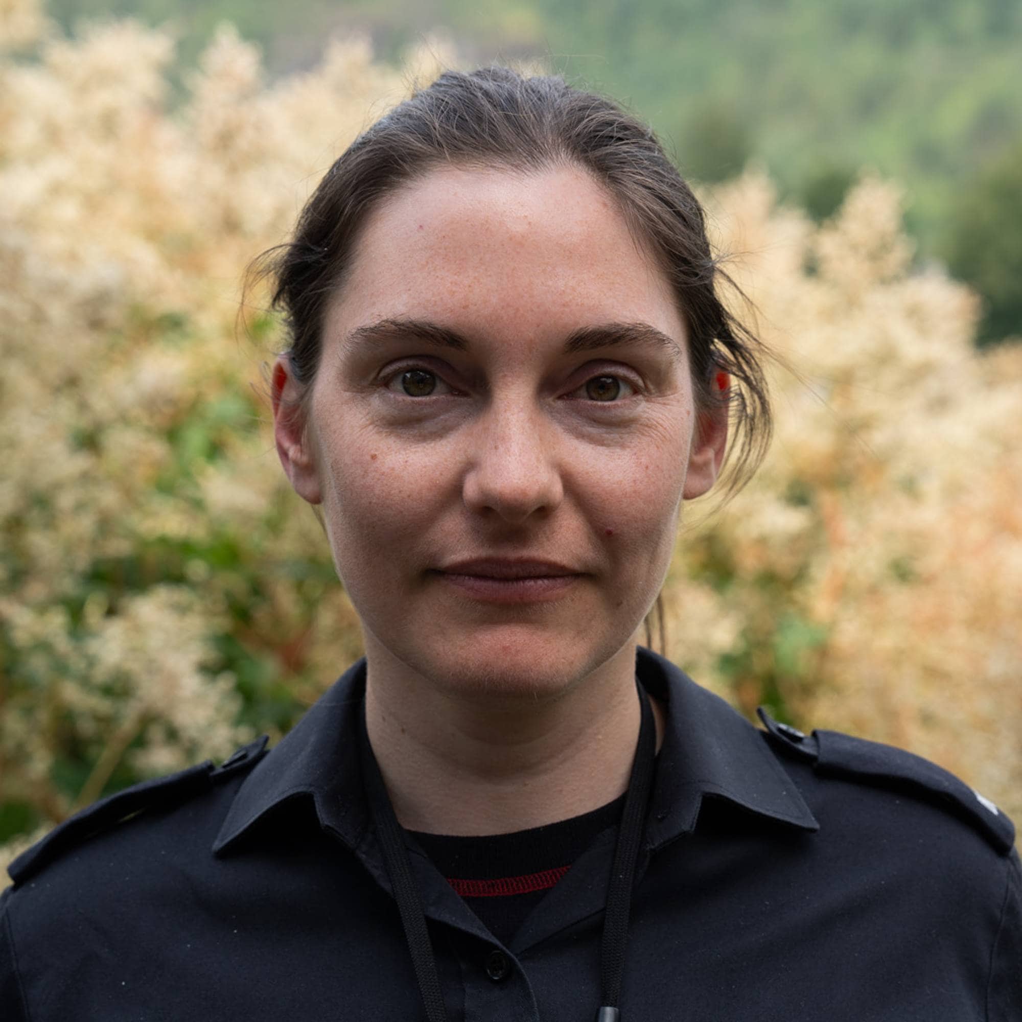 en person som står foran en busk
