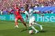 AFP En fotballspiller i hvit drakt under press i en spiller i rød drakt.