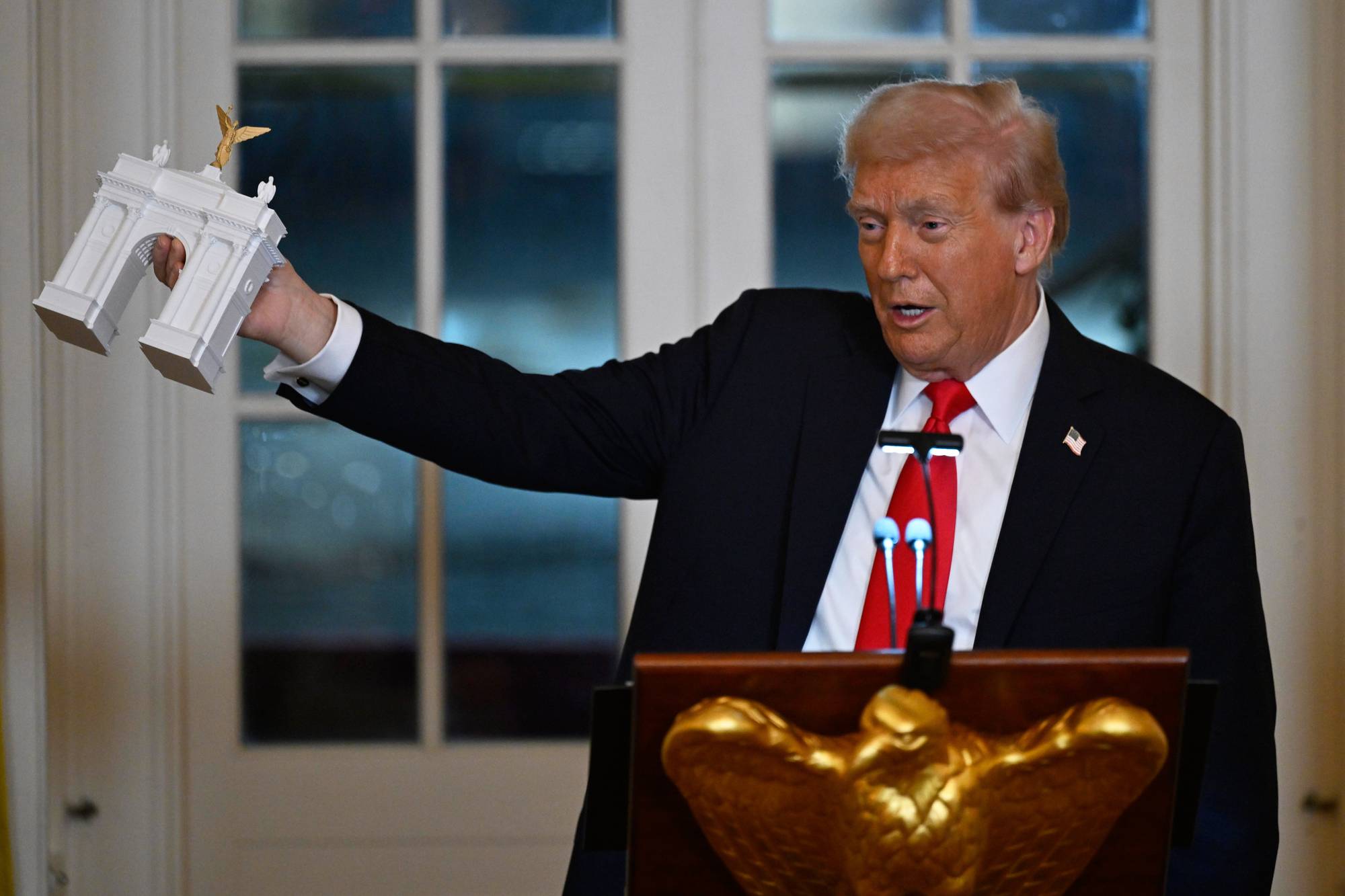 Trump holder opp en modell av den foreslåtte triumfbuen