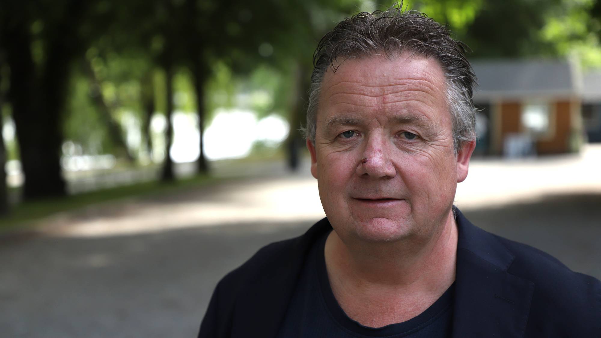 En mann står i en park. 