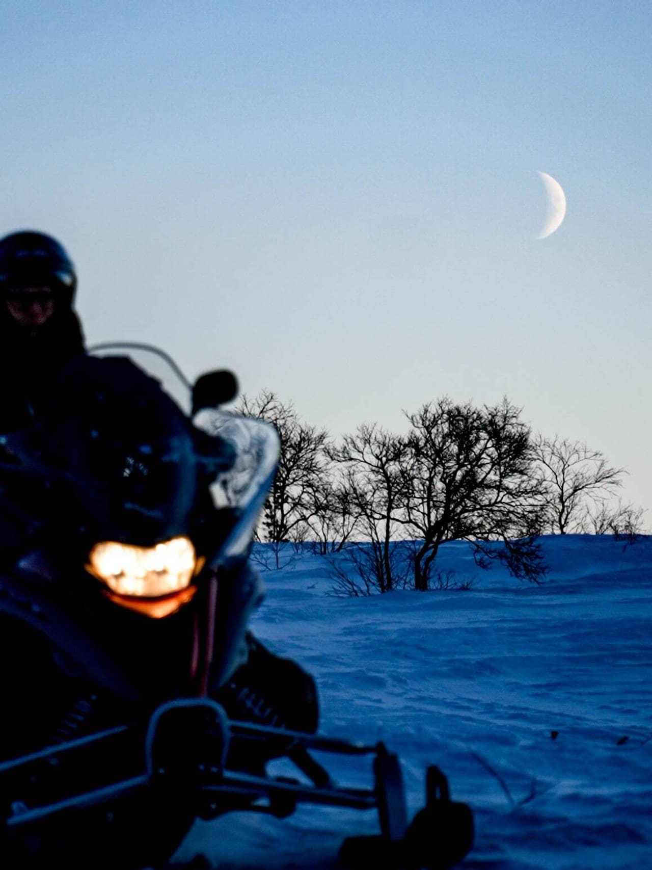 Snøscooter i måneskinn