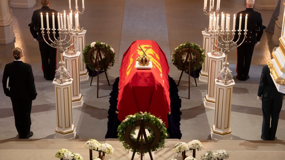 Kong Harald V båre i Slottskapellet, drapert i kongeflagget og kongekronen og rikssverdet. Ved siden av båren står bloqmsterhilsner fra Kongefamilien og FOTO: Cornelius Poppe/Cornelius Poppe / NTB
