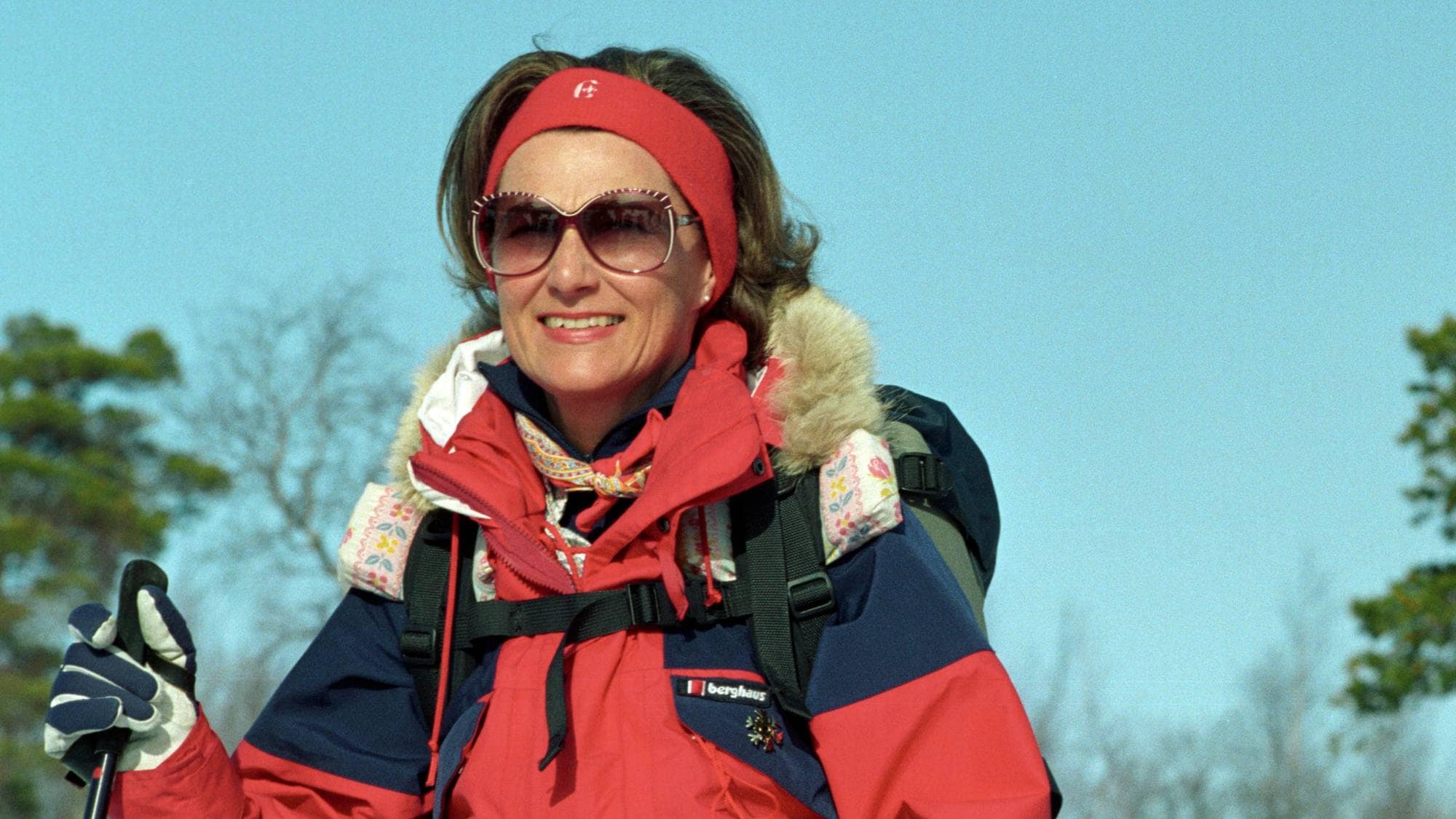 Dronning Margrethe og dronning Sonja på skitur i vinterlandskap, begge kledd i røde jakker. (Bildebeskrivelsen er laget av en KI-tjeneste)