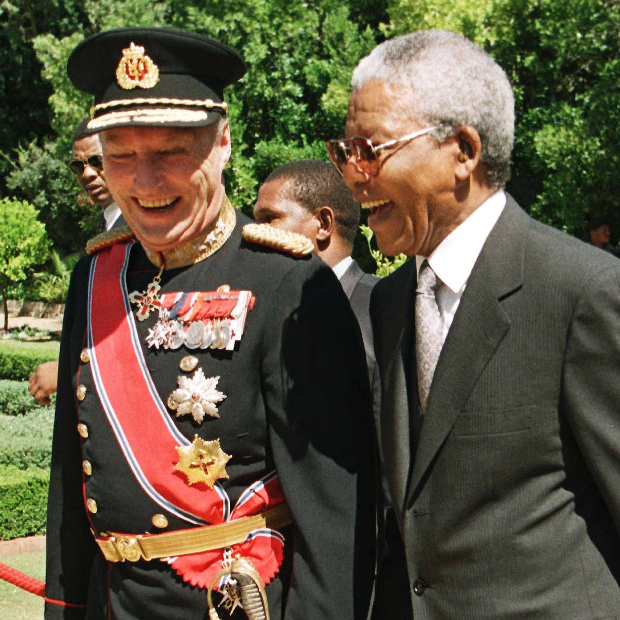 Kong Harald og Sør-Afrikas president Nelson Mandela ler sammen
