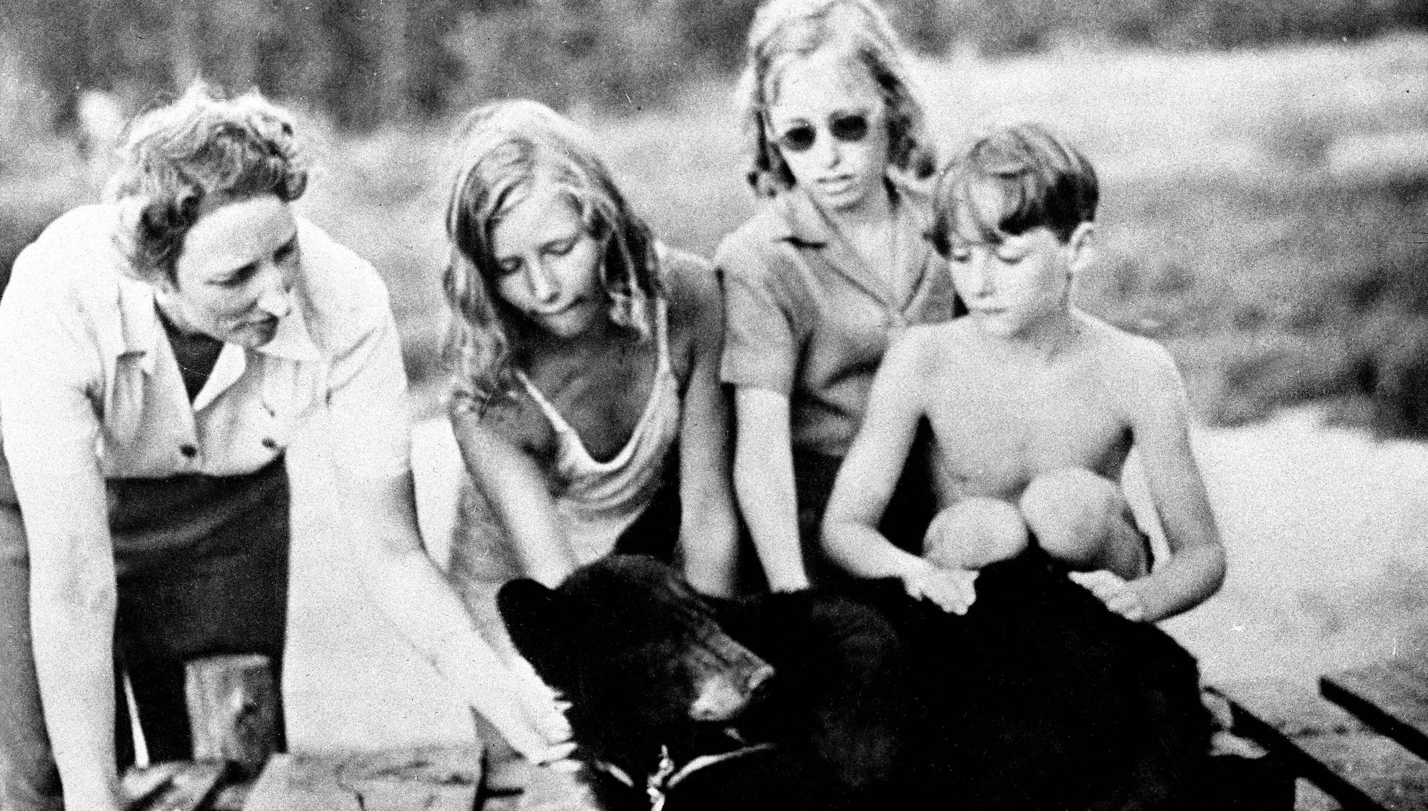 Kronprinsesse Märtha, prins Harald og prinsessene Astrid og Ragnhild klapper en bjørn i Canada