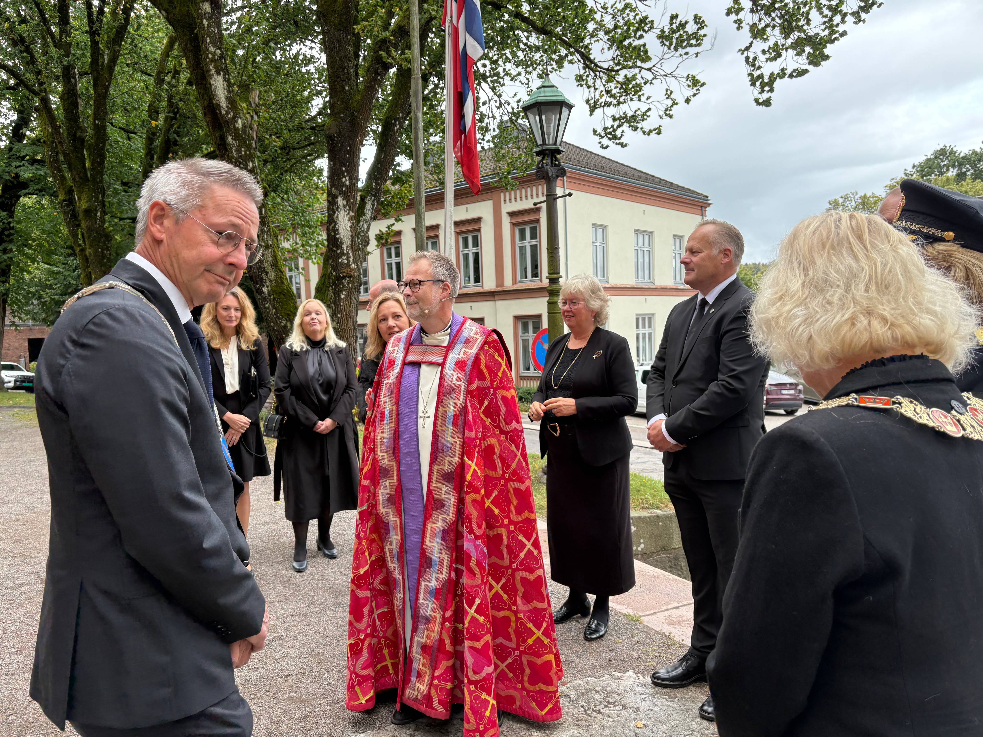 Menn kledd i dress utenfor kirke.