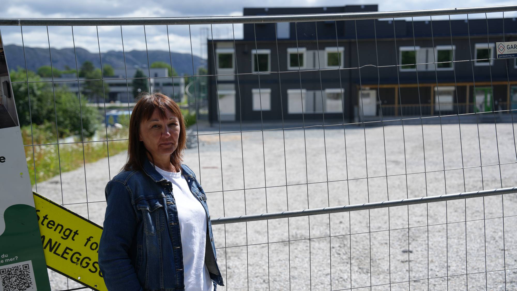 Rektor ved Vaulen skole står foran et gjerde ved modulskolen på Sørmarka i Stavanger.
