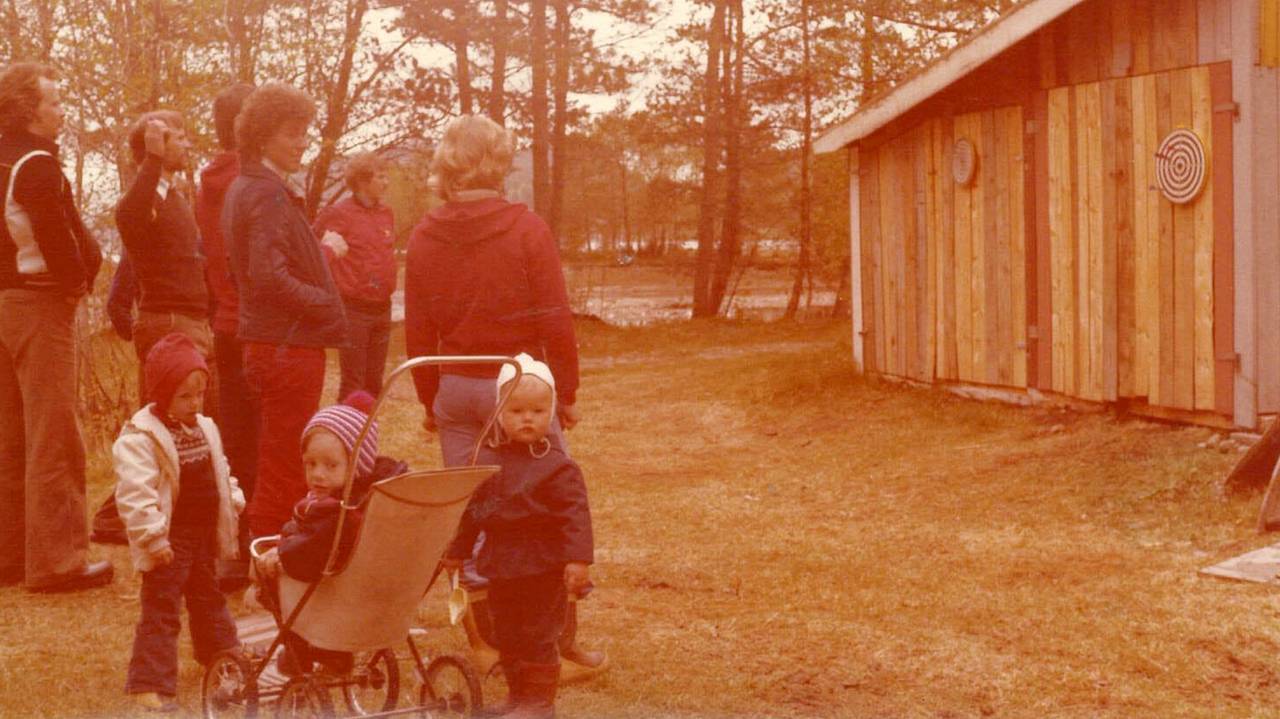 Eva Helen Angvik-Kristiansen sitter i vogn, mens andre barn på hennes alder står rundt henne