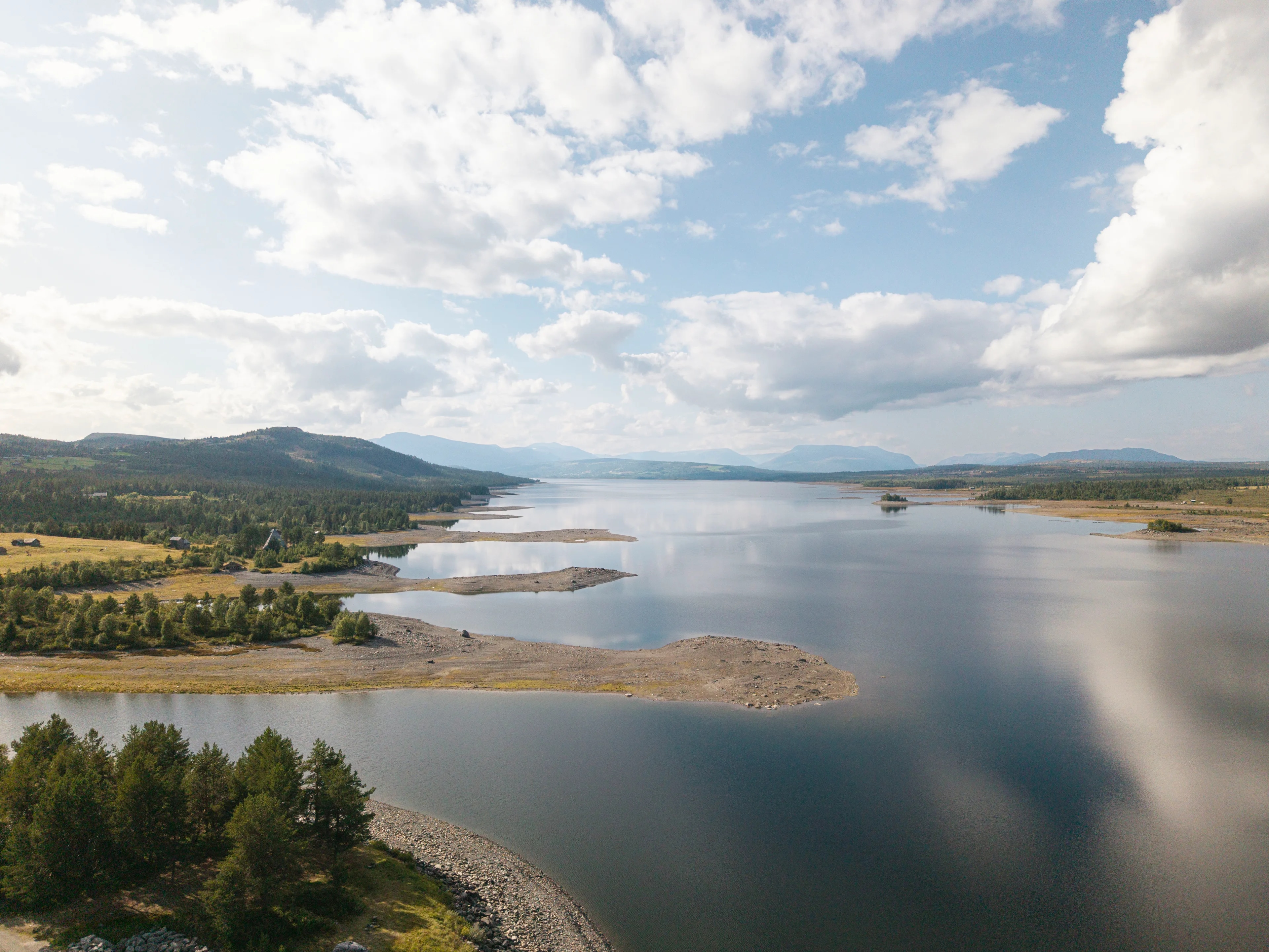 Dronebilde av Tisleifjorden med lav vannstand. Langs kanten ses flere odder som vanligvis er dekket av vann.