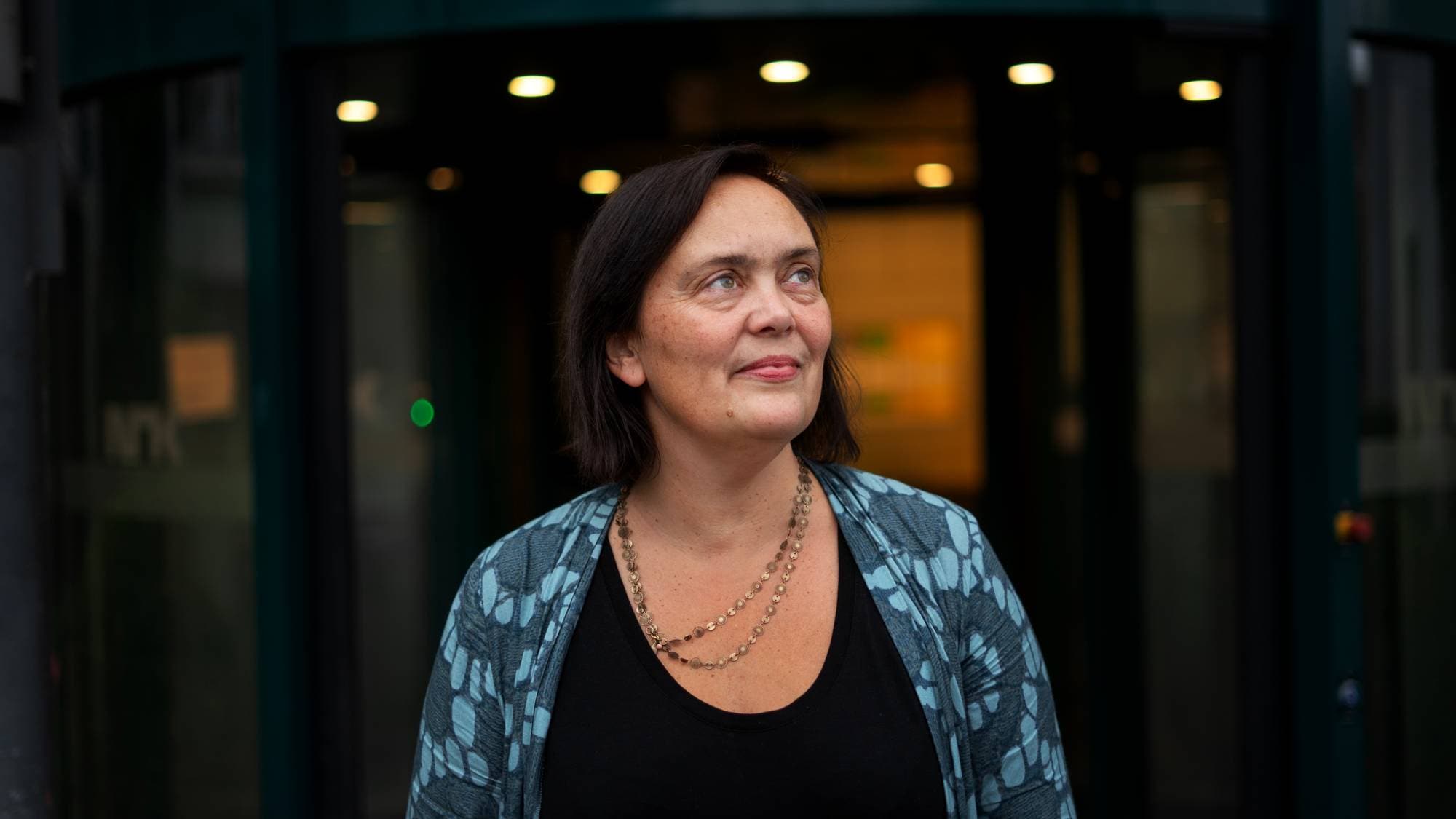 Marte Mangset. Kvinne med kort mørkt hår som ser opp.
