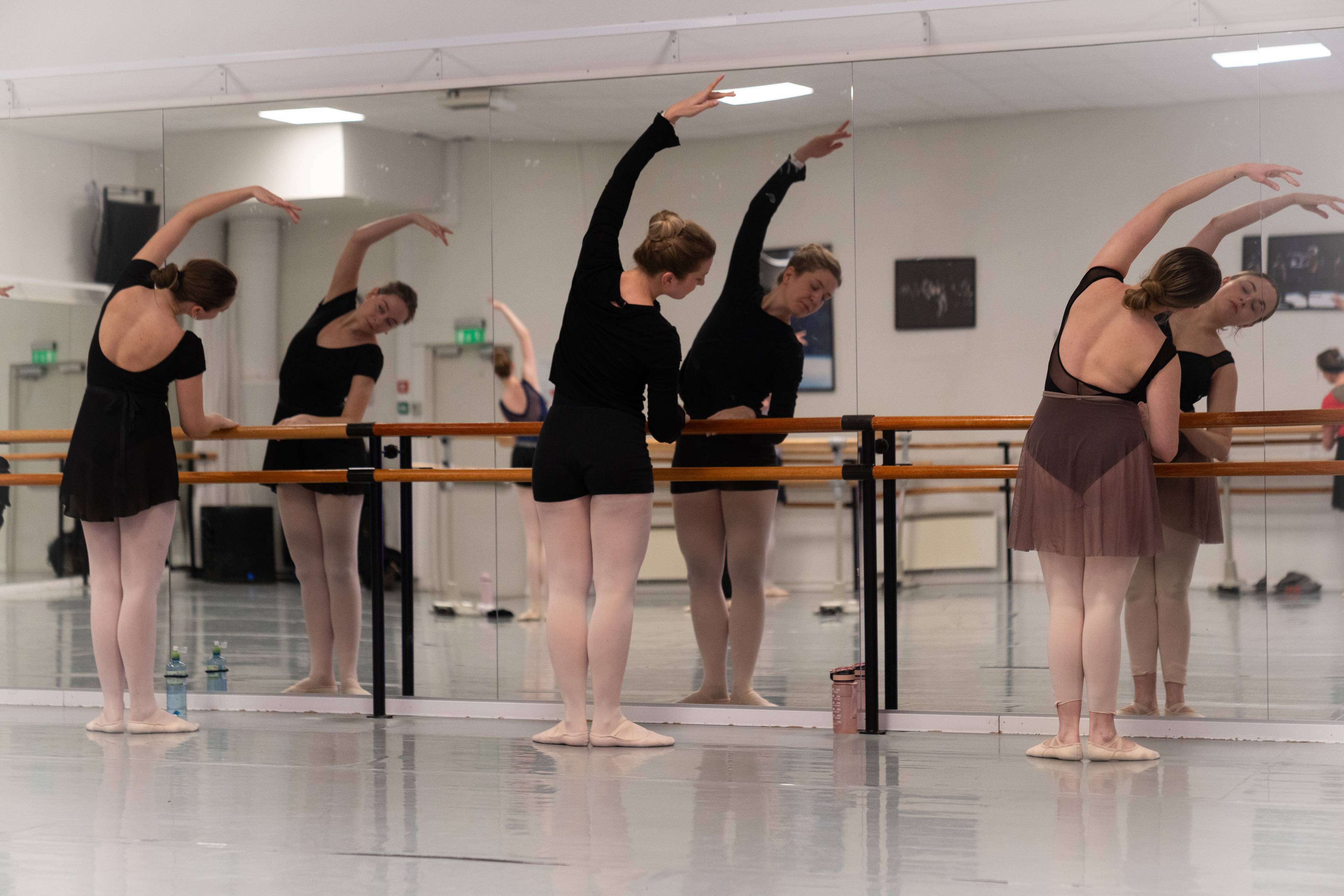 tre kvinner gjør ballettøvelser
