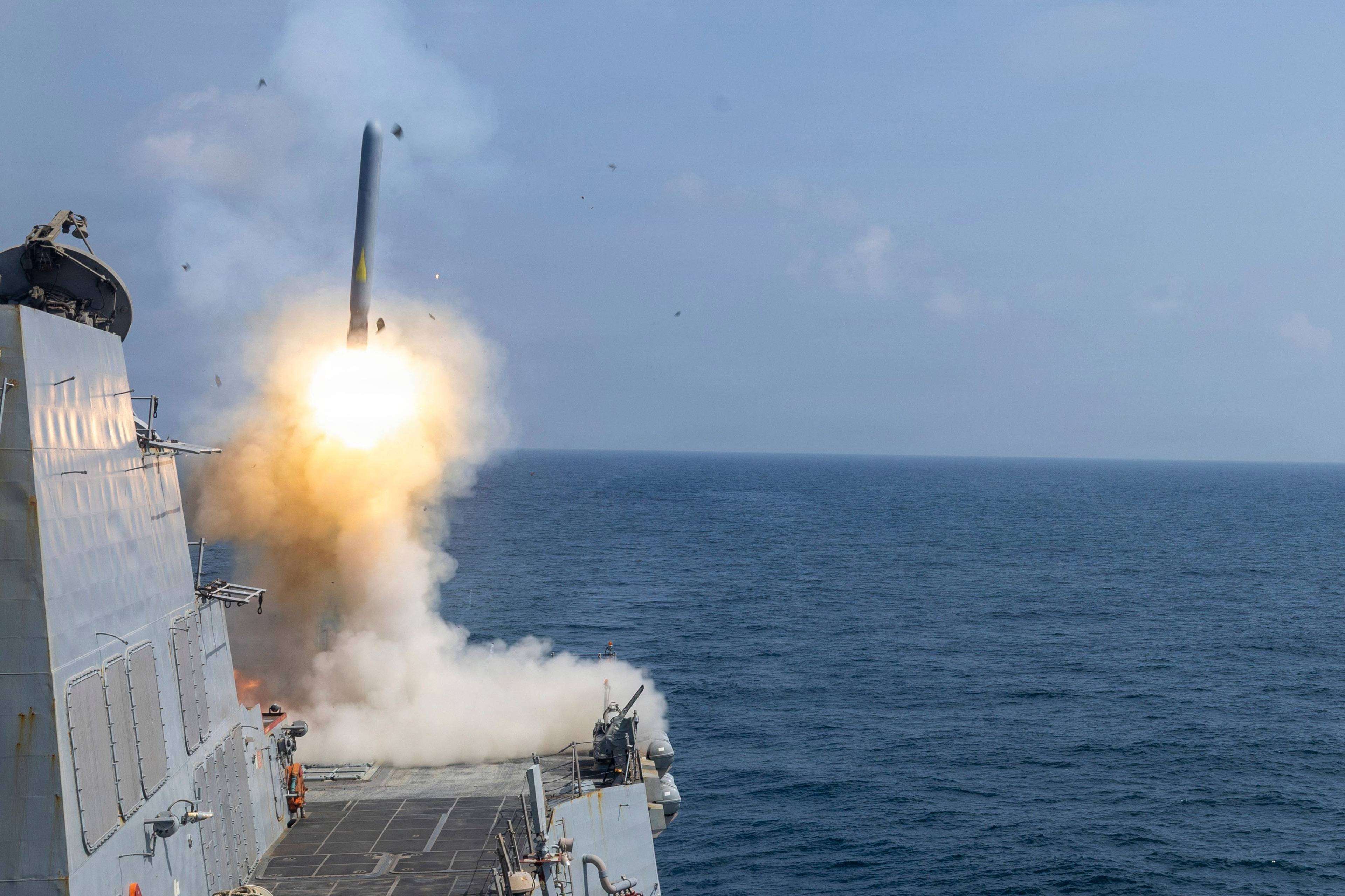 Tomahawk land-missil. Et militærskip på havet som skyter opp en missil.