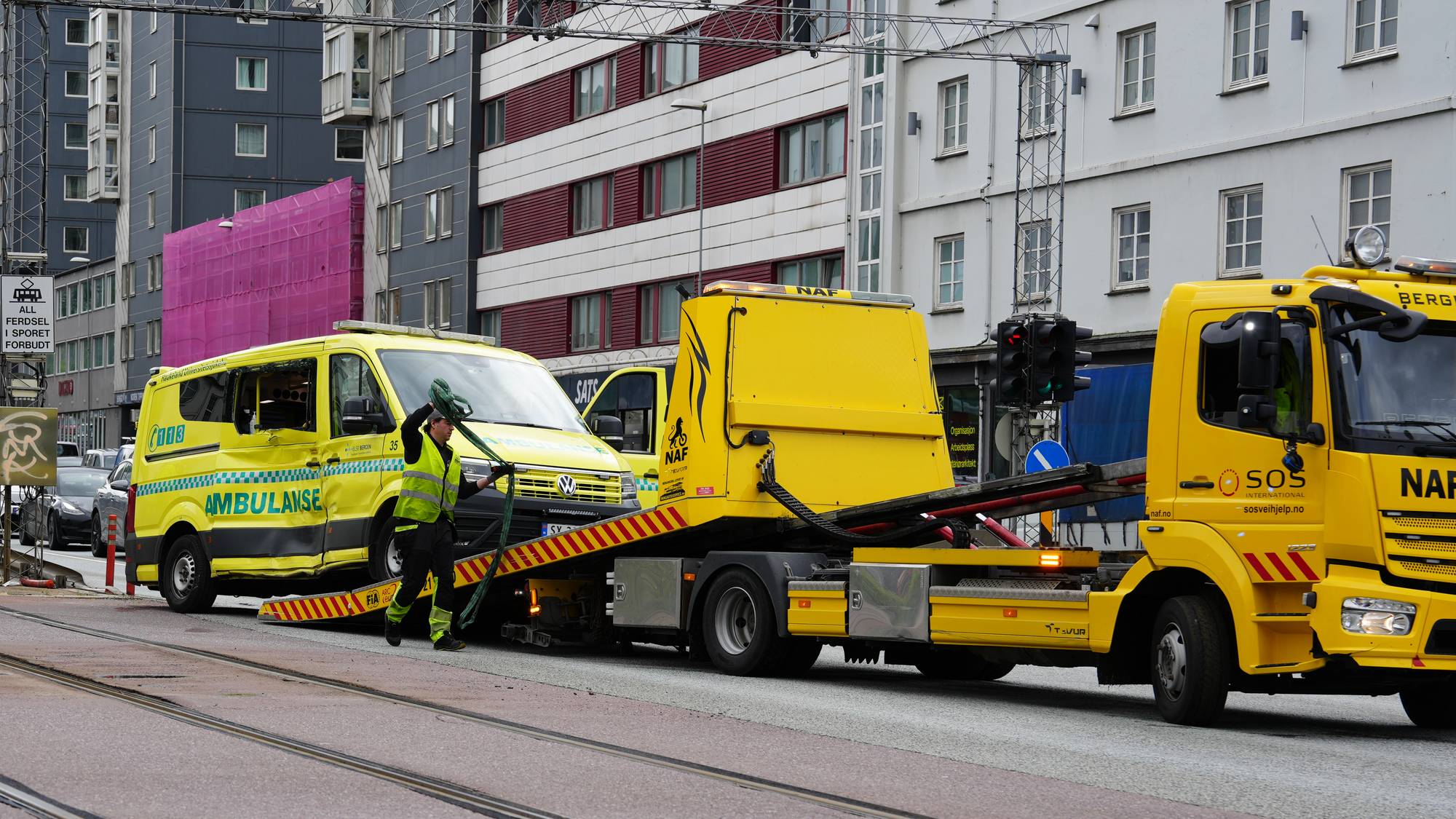 ambulanse med skadar i sida står på berginsbil