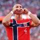 MATTIA OZBOT / GETTY IMAGES NORTH AMERICA,NTB En fotballspiller i Norge-drakt lager hjertesymbol med hendene. Spilleren har nummer fire på drakten. Bakgrunnen viser en fullsatt tribune. (Bildebeskrivelsen er laget av en KI-tjeneste)