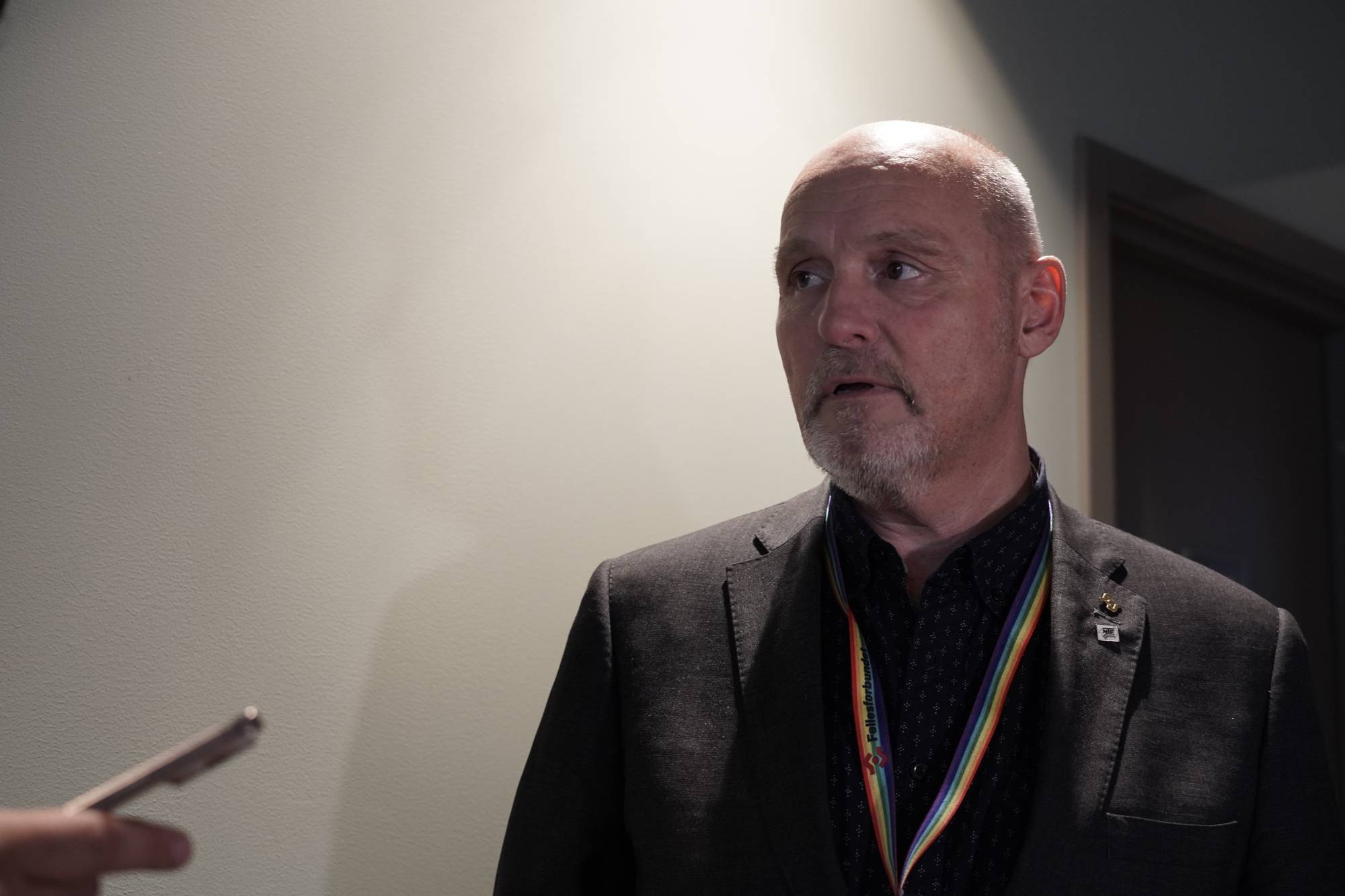 Dag-Einar Sivertsen - Halvnært bilde av mann med brun jakke og sort skjorte, skallet og skjegg. 