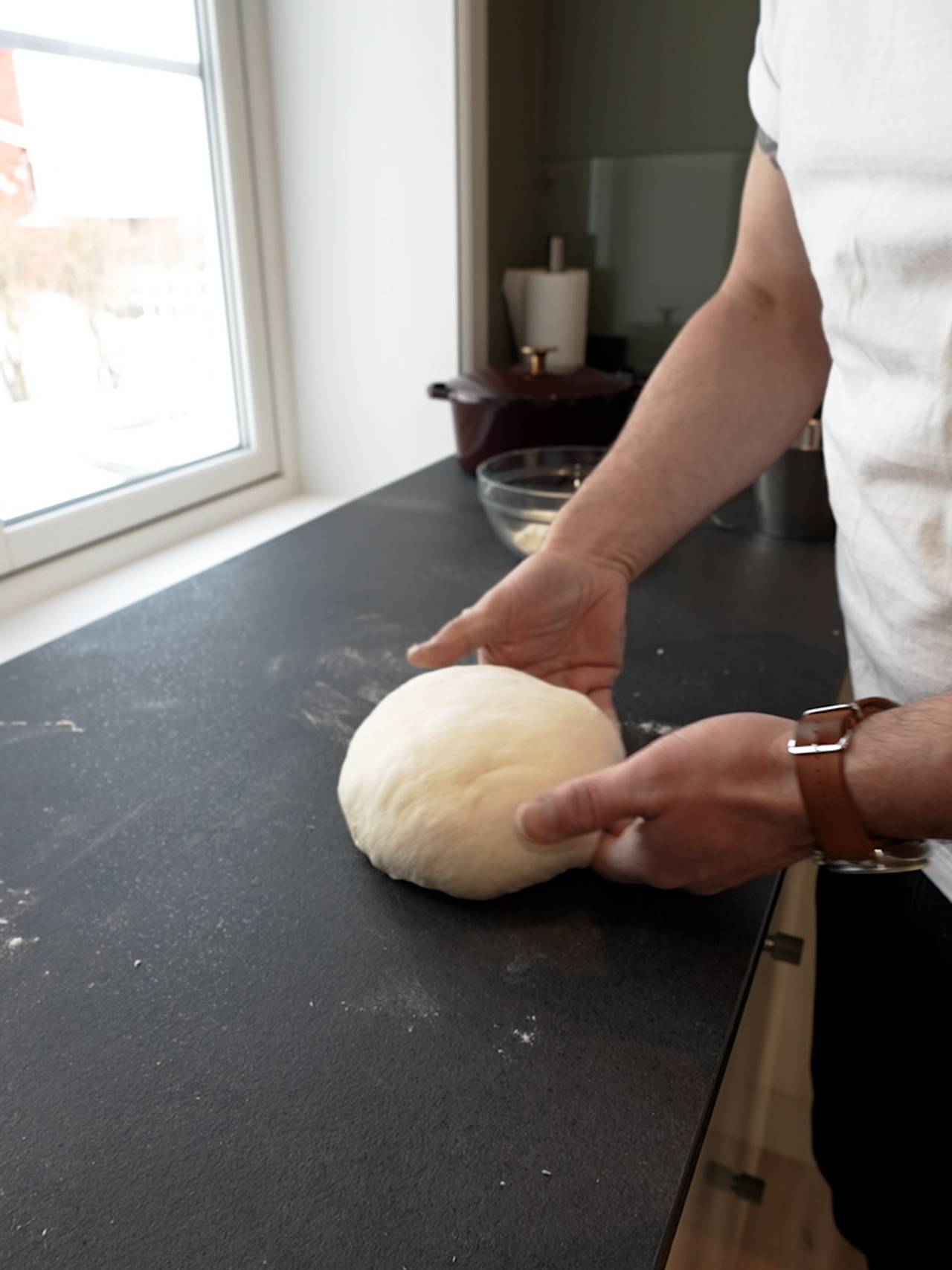 Reuben Quinnell Cleaver former brøddeigen på kjøkkenbenken. 