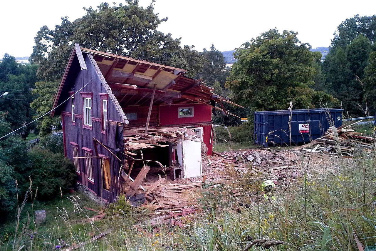 Det brune tømmerhuset på Volla gård ble revet. Halve huset står igjen på dette bildet.