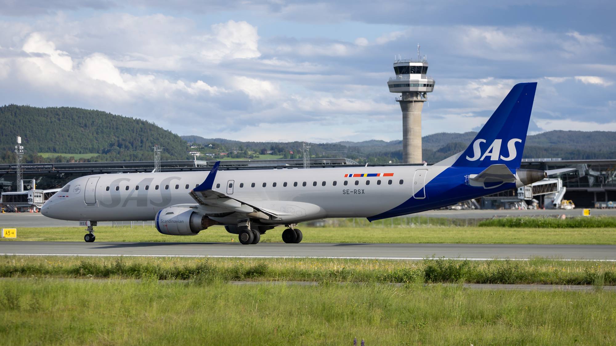 Et mindre SAS-fly har akkurat landet på Værnes. Vi ser tårnet og deler av flyplassen i bakgrunnen