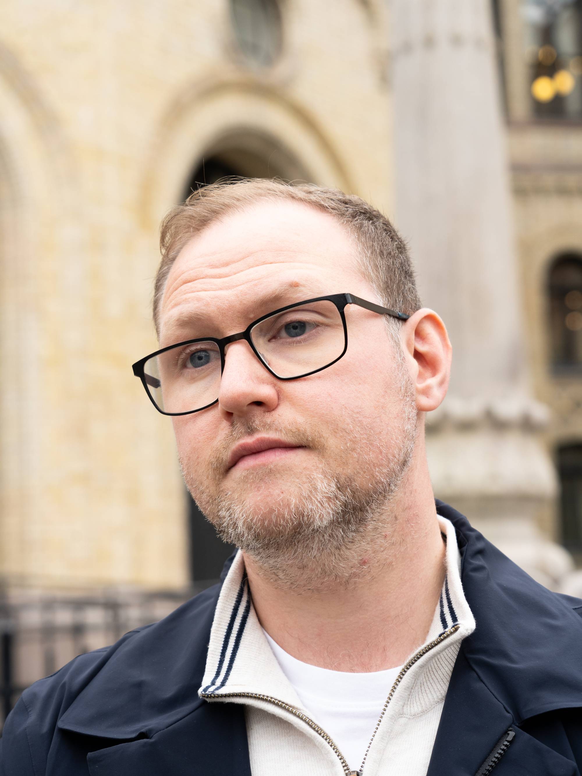 Erlend Svardal Bøe snakker til NRK i et intevju med Stortinget i bakgrunnen