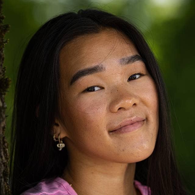 Et portrett av Mali som smiler avslappet til kamera. Hun har mørkt rett hår og mørke øyne.