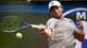 FILIPPO MONTEFORTE / AFP,NTB En mann i hvit caps og grå t-skjorte spiller tennis. Han holder en tennisracket i en slående bevegelse. Bak ham ser man et stort, uklart bilde. Det er en NTB-logo i midten av bildet. (Bildebeskrivelsen er laget av en KI-tjeneste)