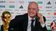 ALFREDO ESTRELLA / AFP,NTB Gianni Infantino, president av FIFA, sitter bak et bord med fotball-VM-trofeet på sin venstre side. Infantino er iført en mørk dress og blått slips. En fotball ligger på bordet til høyre. Bak ham er en vegg med sponsorlogoer. (Bildebeskrivelsen er laget av en KI-tjeneste)