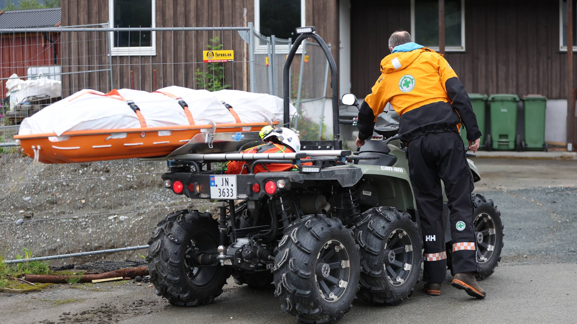 mann stående ved et ATV-kjøretøy
