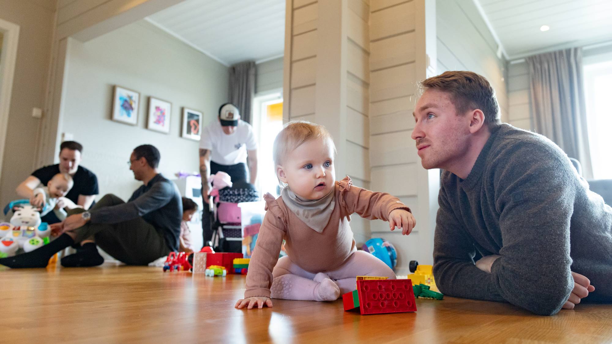 Sindre Solnørdal leker på gulvet med datteren Selma