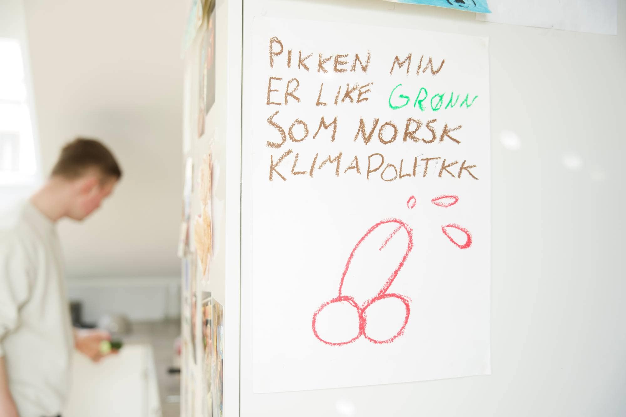 En hjemmelaget tegning henger på kjøleskapet på kjøkkenet i kollektivet. På arket står det: "Pikken min er like grønn som norsk klimapolitikk". 
