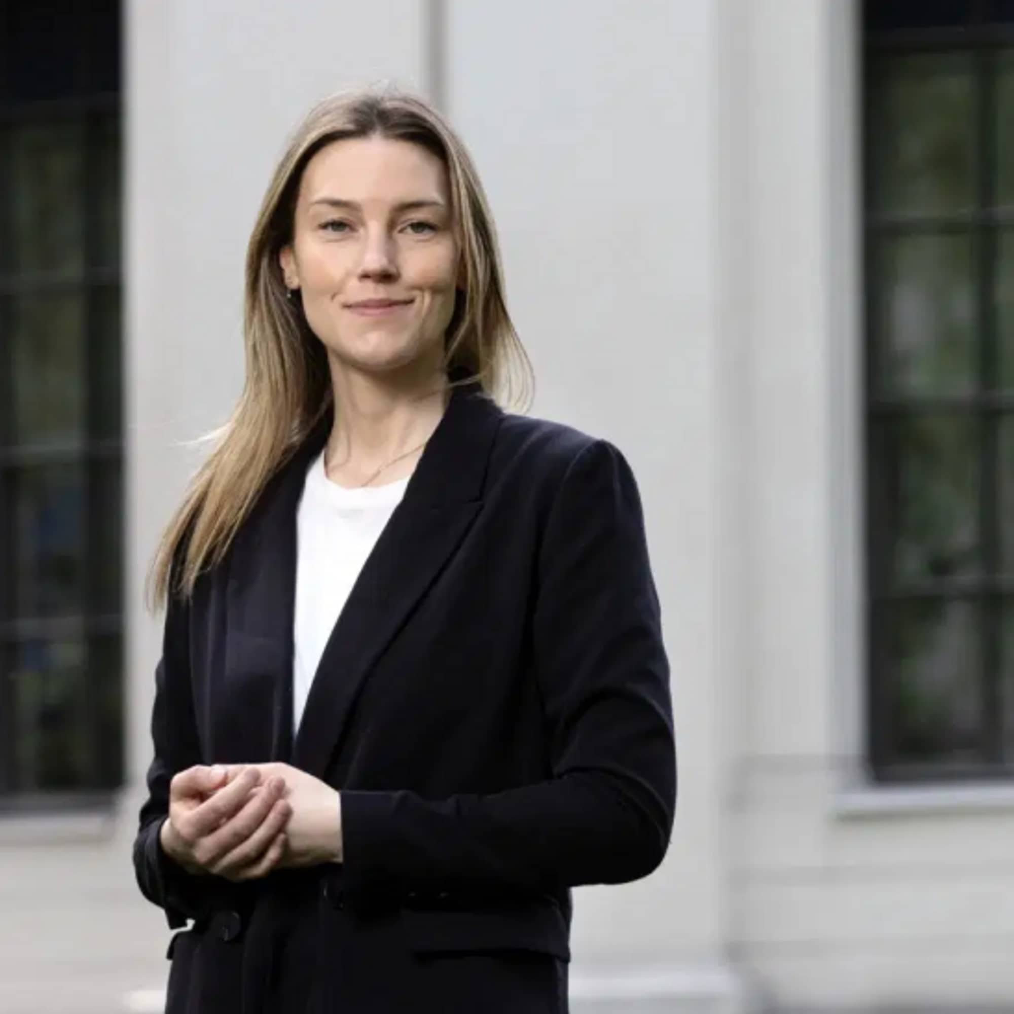 En kvinne står foran en bygning