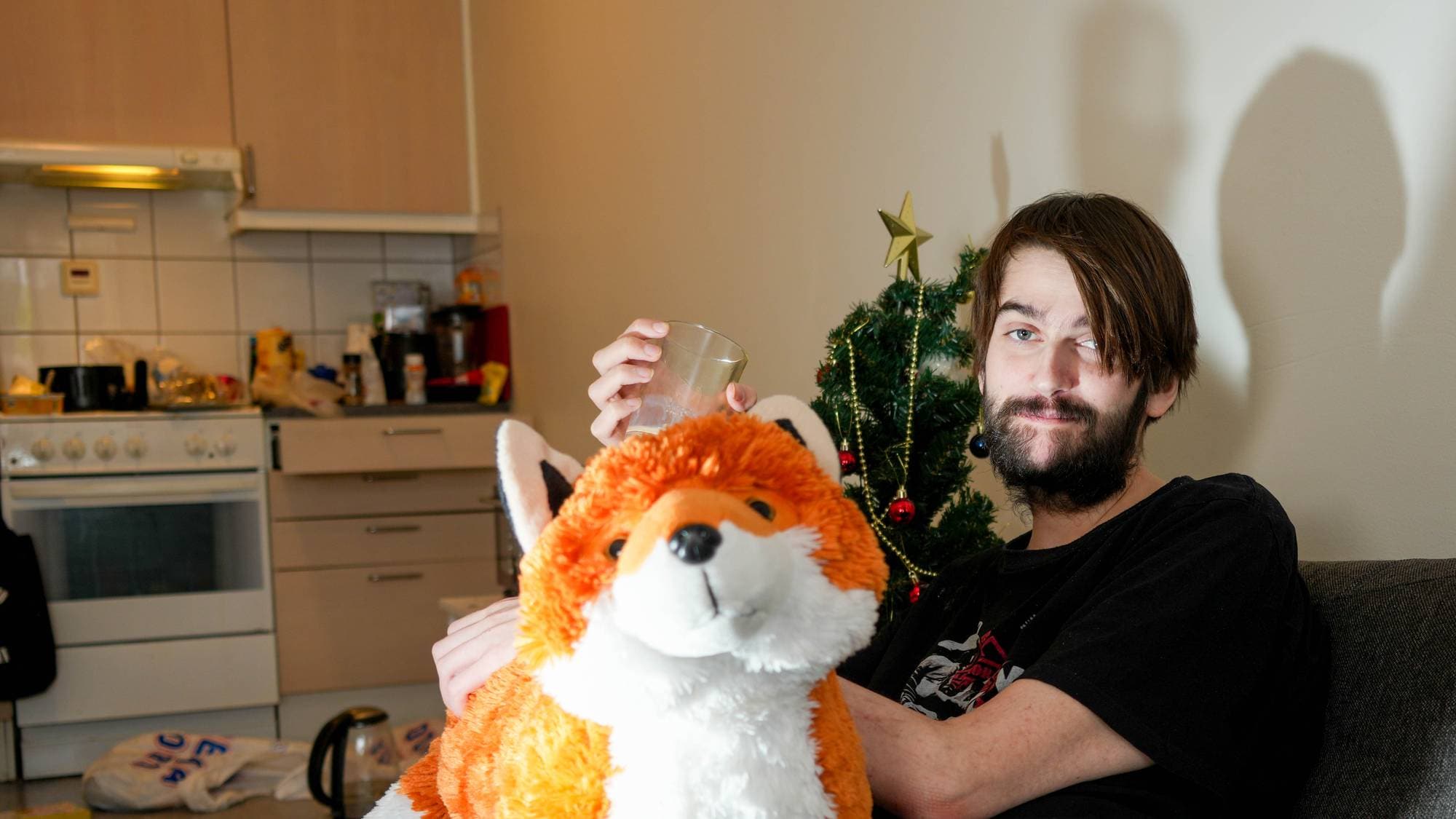 en person som sitter på en sofa med et kosedyr
