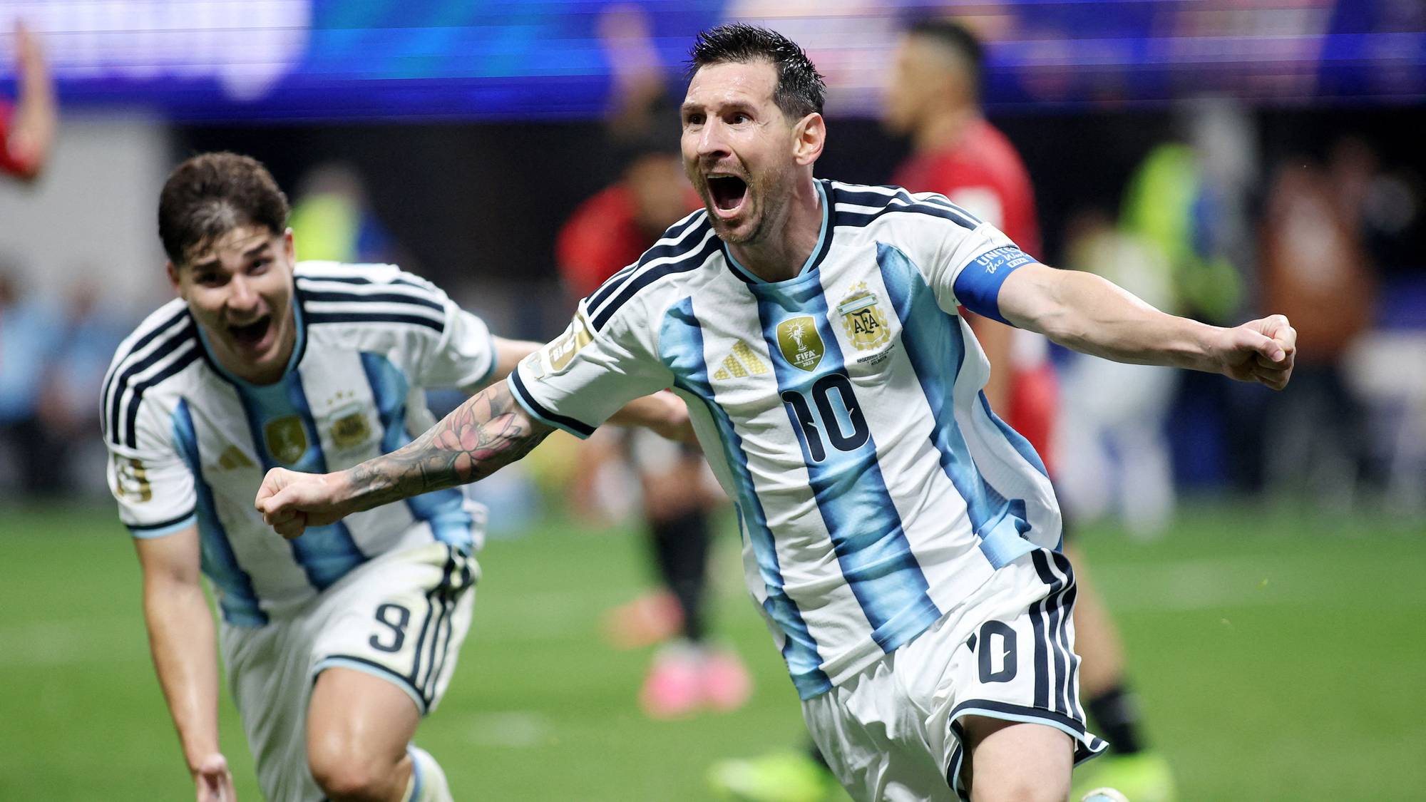 Lionel Messi feirer scoring for Argentina sammen med Julián Álvarez på en fotballbane. (Bildebeskrivelsen er laget av en KI-tjeneste)