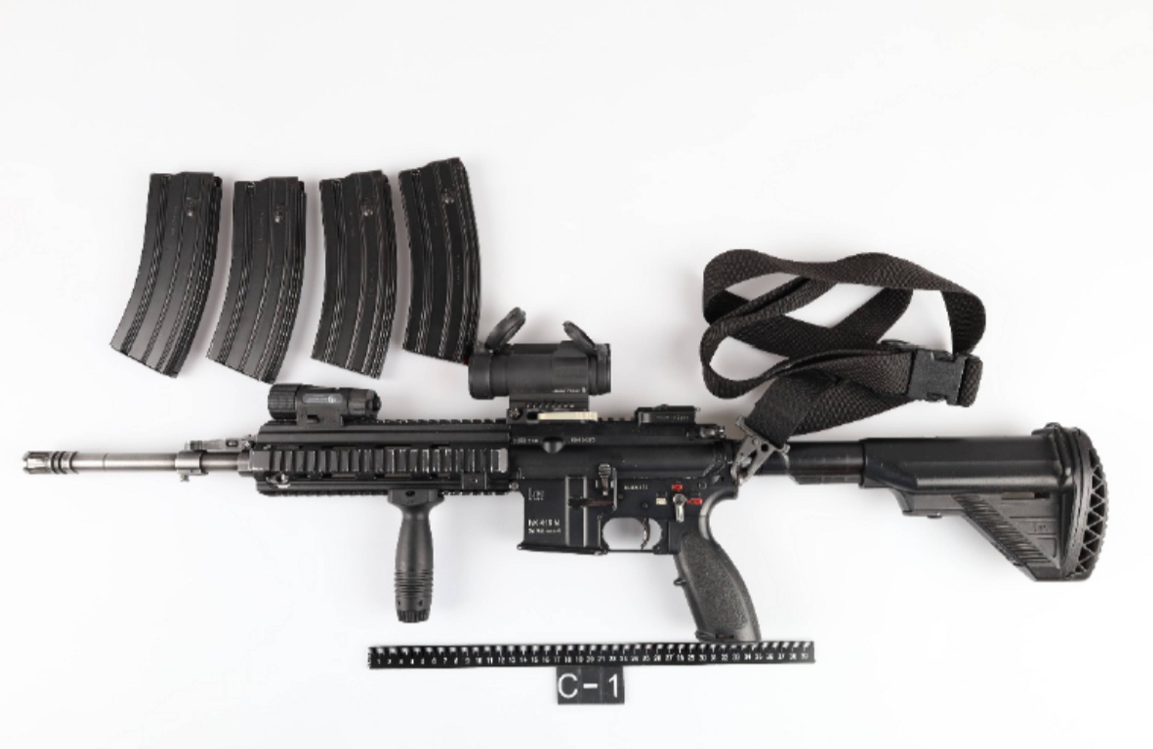 Et beslaglagt HK416-gevær med fire magasiner, reim og en linjal med merkelapp C-1.