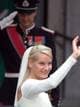 Lise Åserud / AP Mette-Marit Tjessem Høiby vinker når hun ankommer Oslo domkirke for å gifte seg med kronprins Haakon. I bakgrunnen sees kronprinsen mens han gjør honnør.