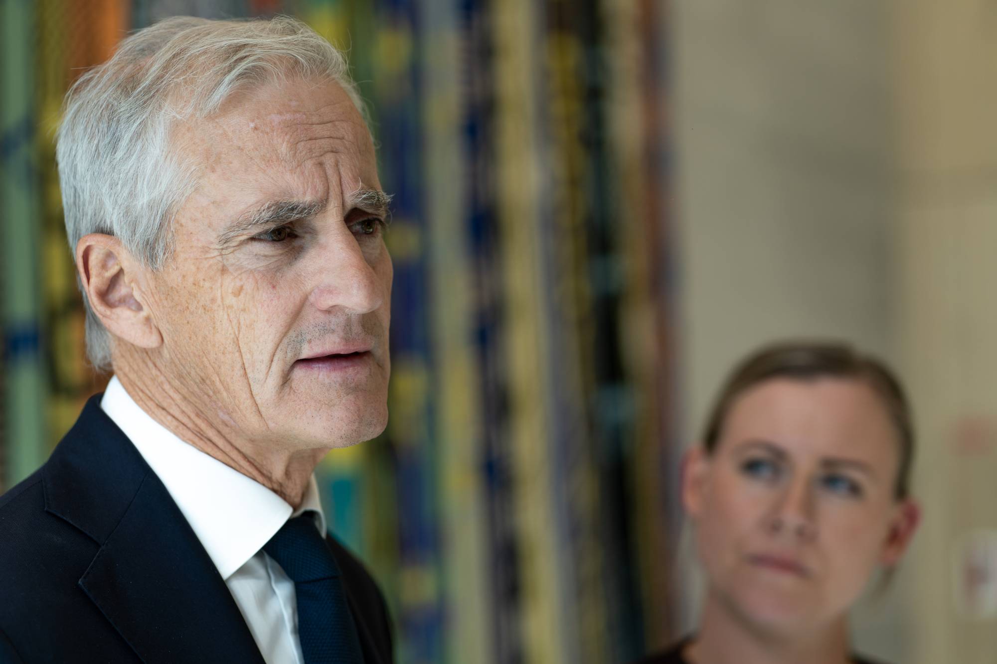 Jonas Gahr Støre og Lene Vågslid snakker til NRK med en fargerik vegg i bakgrunn
