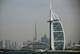 GIUSEPPE CACACE / AFP,NTB En hvit seilformet bygning, Burj Al Arab, står til høyre. I bakgrunnen ses en lang, pyramideformet bygning og andre høye bygninger, inkludert Burj Khalifa. Bildet viser Dubais skyline ved vannkanten. Landskapet er overskyet. (Bildebeskrivelsen er laget av en KI-tjeneste)