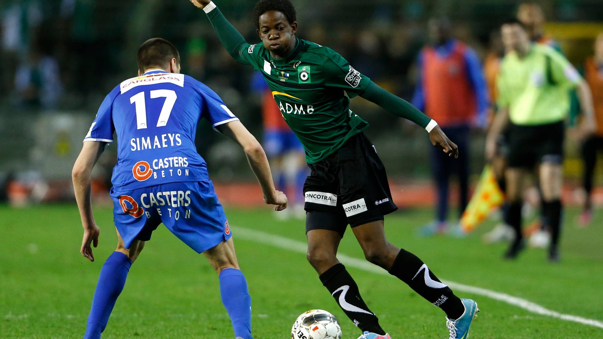 To fotballspillere i en duell om ballen på en gressbane. (Bildebeskrivelsen er laget av en KI-tjeneste)