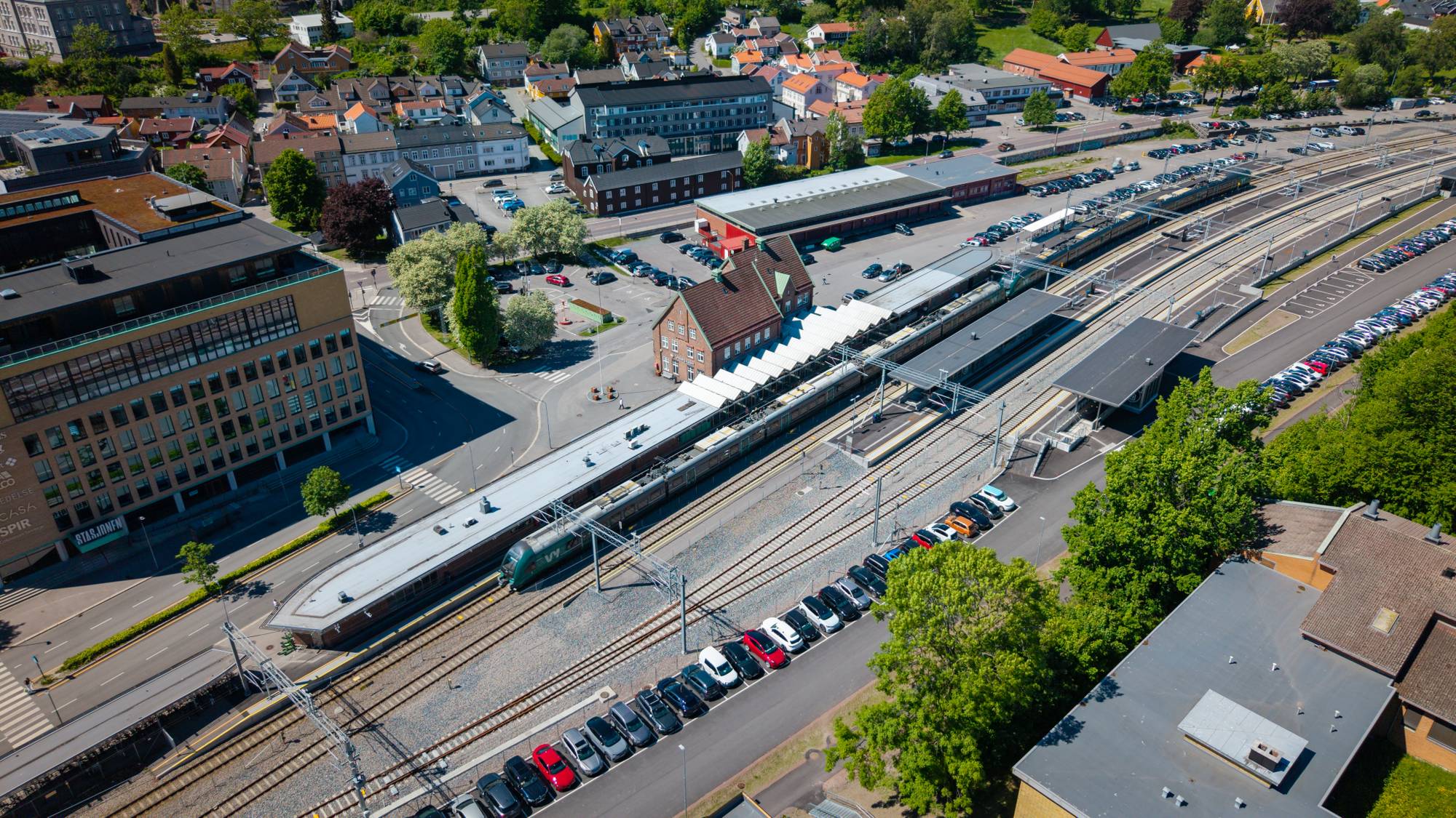 Luftfoto av et tog som har stoppet ved en stasjon.