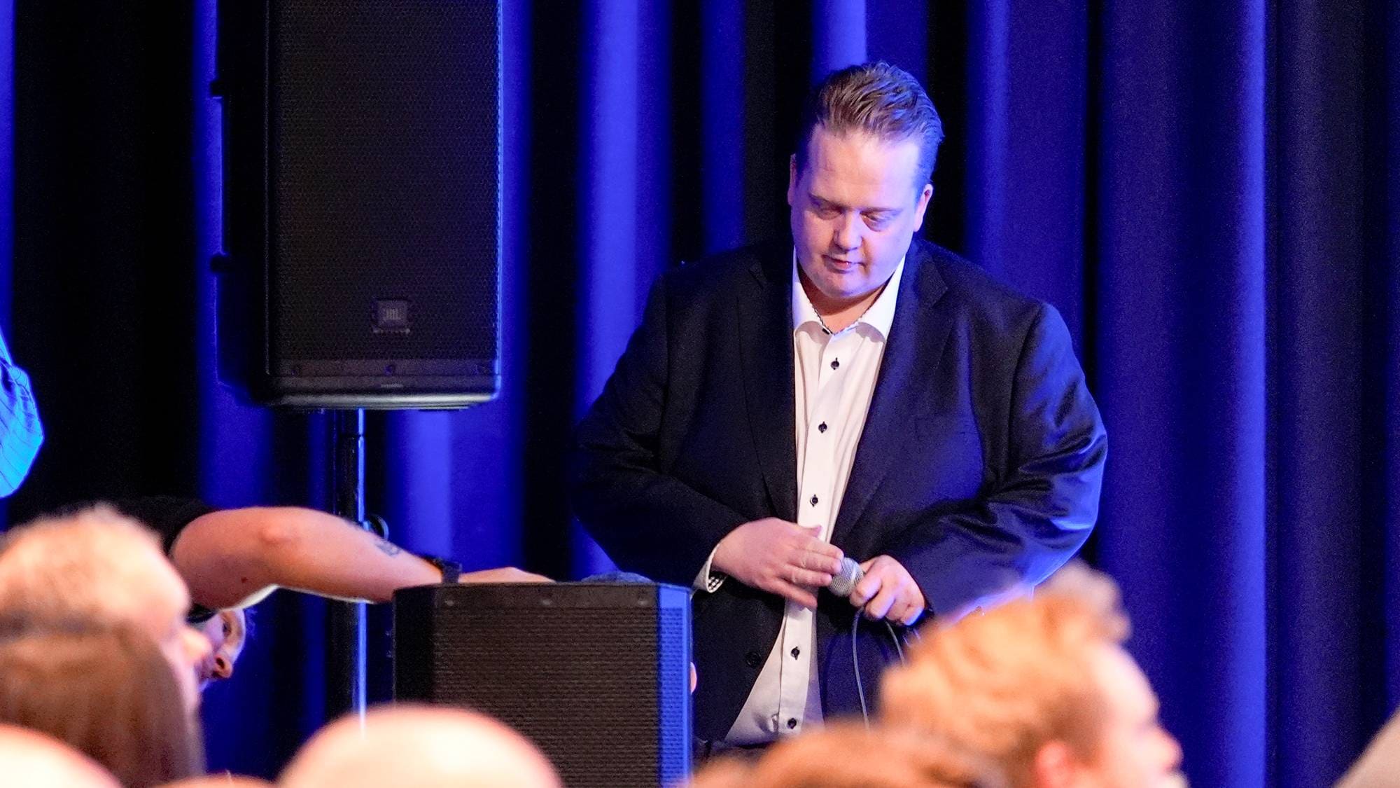 Helge Fossum annonserer at Sylvi Listhaugs tale på høstkonferansen blir utsatt med over en time på grunn av tekniske problemer.