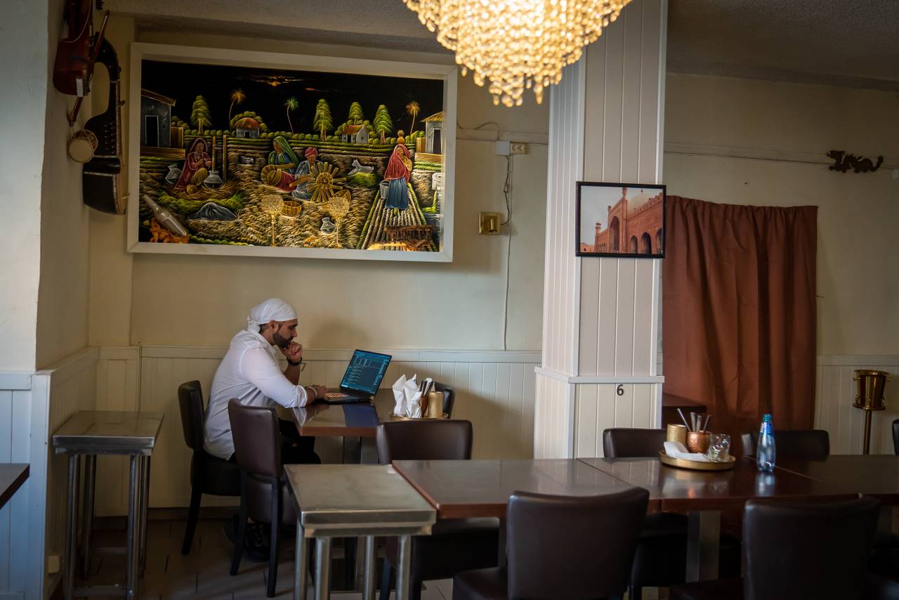 Daravir Singh sitter med laptop i restauranten