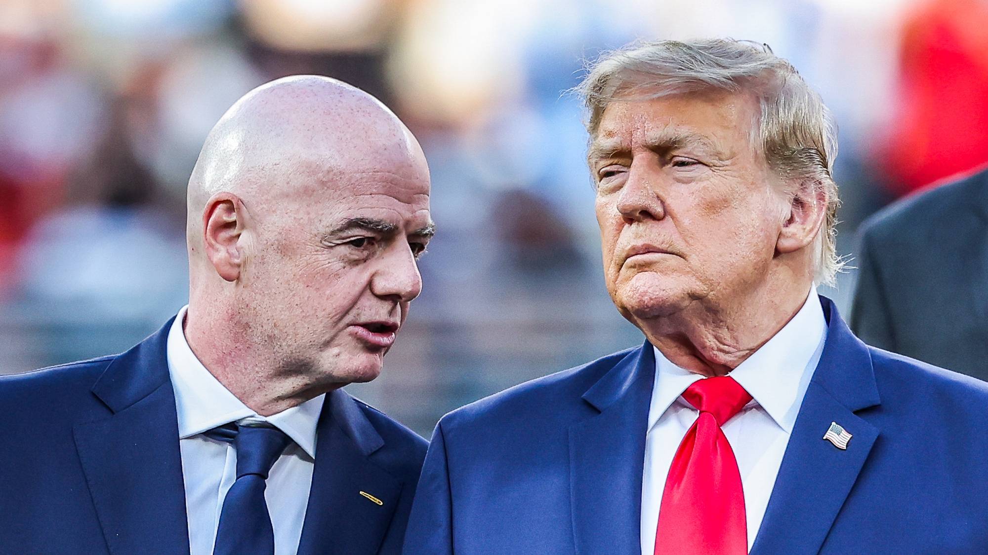 Gianni Infantino og Donald Trump snakker sammen på et podie