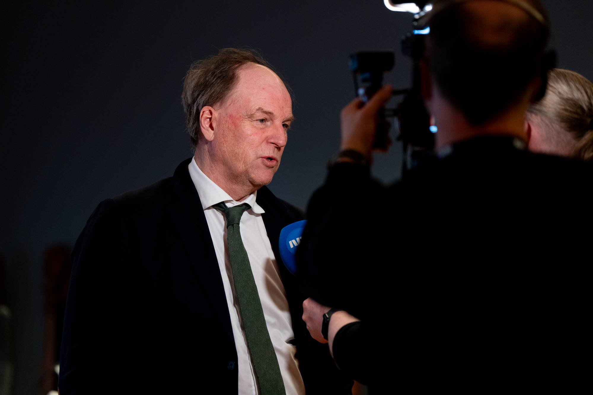 En mann i dress blir intervjuet