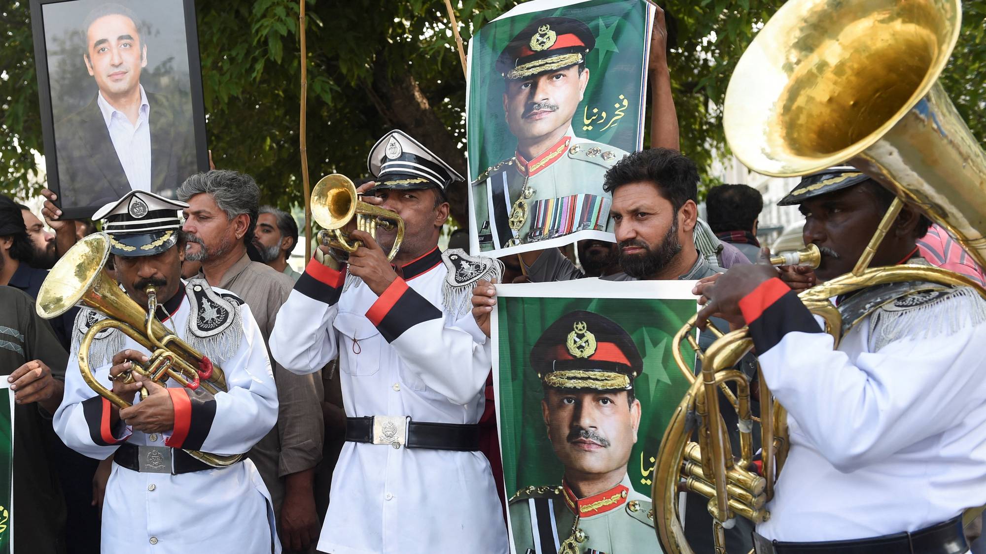 Et band spiller i en feiring og holder plakater av Pakistans hærfører Asim Munir og politikeren Bilawal Bhutto Zardari.